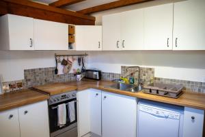 a kitchen with white cabinets and a sink at Insolit'appart à la ferme in Horbourg