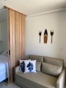 a living room with a couch and two surfboards on the wall at Flat Garden 02-A - Beach Class Verano - Porto de Galinhas in Ipojuca