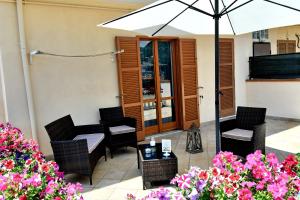a patio with a table and chairs and an umbrella at Villa Soraya in Cava deʼ Tirreni