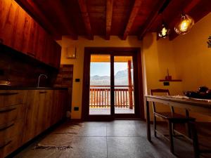 a kitchen with a door leading to a balcony at Rosetta - Ai Meli - Dolomites in Lozzo Cadore