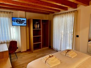 a bedroom with a bed and a tv on a wall at Rosetta - Ai Meli - Dolomites in Lozzo Cadore