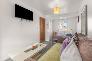 a living room with a couch and a tv on a wall at Badger Haven, Apartment 1 in Brackley +23 photos