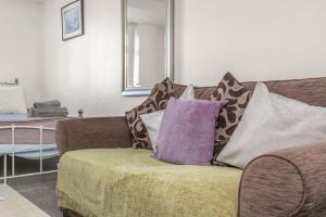 a couch with pillows on it in a living room at Badger Haven, Apartment 1 in Brackley