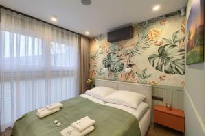 a bedroom with a large bed with a floral wallpaper at Cicho Sza in Tylicz