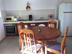 a kitchen with a wooden table and chairs and a refrigerator at Résidence Le Lagon in Sainte-Anne +34 photos