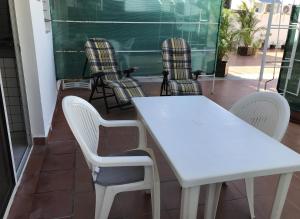 a white table and chairs in front of a classroom at Résidence Le Lagon in Sainte-Anne