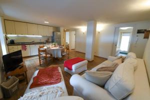 a living room with a white couch and a table at Sant'Orso Cozy Home in Cogne