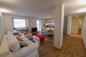 a living room with a white couch and a kitchen at Sant'Orso Cozy Home in Cogne