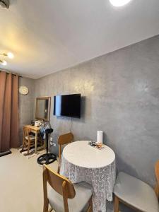 a room with a table and chairs and a tv at Cozee Staycations in Lapu Lapu City