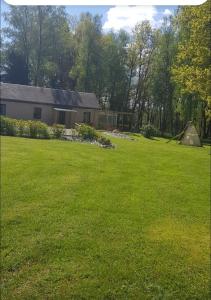 a yard with a house and a tent in it at La croix majot in Regniowez