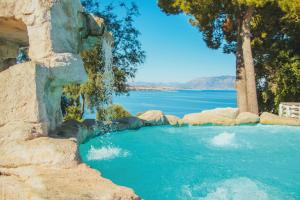 a swimming pool with a waterfall and a body of water at CDSHotels Terrasini - Città del Mare in Terrasini +78 photos