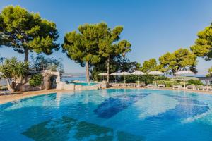 a large swimming pool with trees in the background at CDSHotels Terrasini - Città del Mare in Terrasini