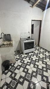 a kitchen with a microwave sitting on a tiled floor at Casa da Biza 1 in Cananéia