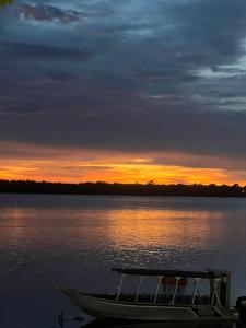 a boat sitting on the water at sunset at Casa da Biza 1 in Cananéia