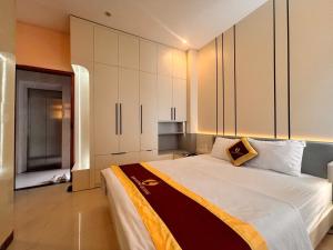 a bedroom with a large bed with white cabinets at Phú Quốc STAR hotel in Phú Quốc
