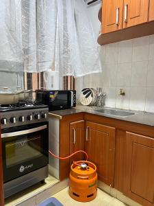 a kitchen with a stove and a pot on the floor at Stylish 1br Milimani in Kisumu +6 photos