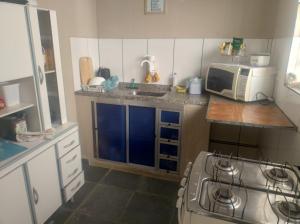 a small kitchen with a stove and a microwave at Suites no centro, Salto-SP in Salto