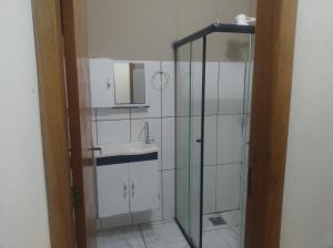 a bathroom with a sink and a glass shower at Suites no centro, Salto-SP in Salto +12 photos
