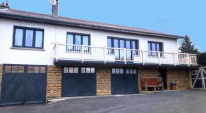 a house with a balcony and a garage at Le lavoir in Moiry