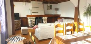 a living room with a white couch and a fireplace at Le lavoir in Moiry