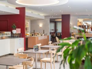 a restaurant with tables and chairs and a counter at B&B HOTEL Eurorest Conegliano in Conegliano