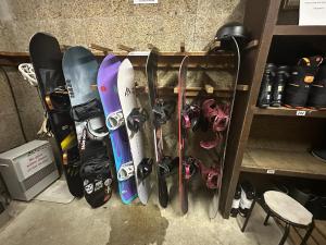 a bunch of snowboards are lined up on a shelf at Santana Lodge Hakuba in Hakuba +39 photos