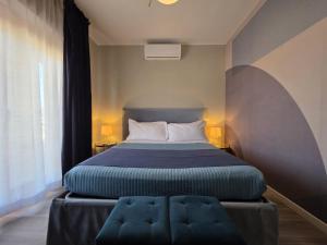 a bedroom with a bed with a blue foot stool at Guest House Seataly - by Be Your Home in Civitavecchia