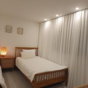 a bedroom with a bed with a white curtain at COZY stay in Seoul