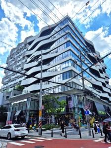 a tall building with people walking in front of it at COZY stay in Seoul