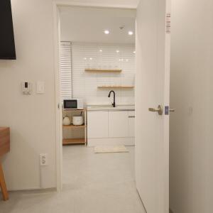 a white kitchen with a sink and a counter at COZY stay in Seoul