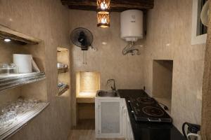 a small kitchen with a stove and a sink at بيت العريش Arish house in Sayq +7 photos