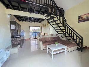 a living room with a couch and a spiral staircase at Shukran Habibi Resort in Santa Rita