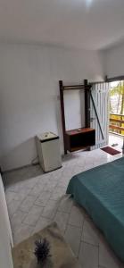 a white room with a bed and a window at Verde & Sal 13 in Ilhéus