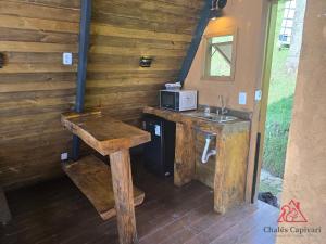 a kitchen with a counter and a sink in a cabin at Chale Capivari Estrela in Campos do Jordão