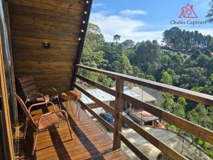 a balcony with chairs and a view of the mountains at Chale Capivari Estrela in Campos do Jordão