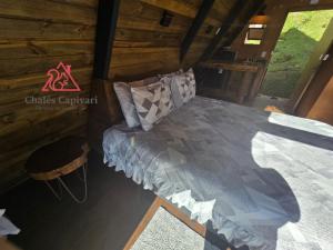 a bedroom in a log cabin with a bed at Chale Capivari Estrela in Campos do Jordão +2 photos