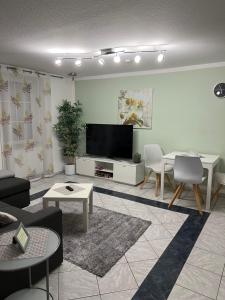 a living room with a flat screen tv on a wall at Ferienwohnung „ Zum Josefstal „ in Sankt Ingbert