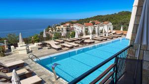 a swimming pool with lounge chairs and the ocean at Arabela 2 Apartments in Utjeha