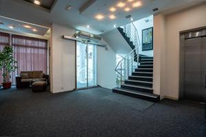 a lobby with a staircase in a building at Hotel Golf Luxury in Kruševac