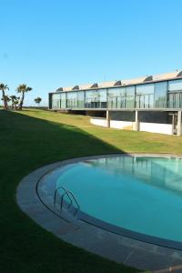 a large swimming pool in front of a building at Bloom - Beach House in Apúlia