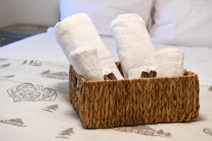 a basket filled with towels on a bed at Sant'Orso Cozy Home in Cogne