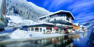 a building covered in snow next to a mountain at Bei die Gstrein's in See