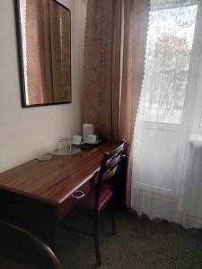 a wooden desk with a chair next to a window at Motel Poltava in Poltava