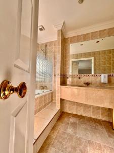 a bathroom with a tub and a sink and a mirror at The Dawson Hostel - DUBLIN in Dublin