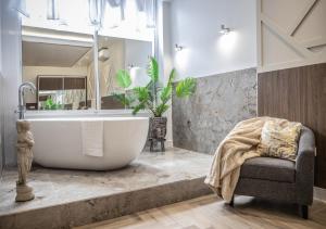 a bathroom with a large tub and a chair at The Pocklington Aparthotel - Luxury 1 & 2 Bed Serviced Apartments, City Centre, Perfect For Families, Contractors and Businesses in Leicester +252 photos