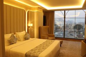 a hotel room with a bed and a large window at Lalit hotel in Udaipur