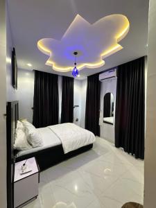 a bedroom with a bed with a cloud ceiling at The NookHouse in Calabar