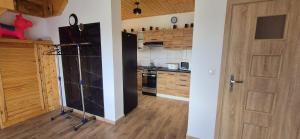 a kitchen with a wooden floor and a door at Domek Na Hawajach in Polana +16 photos