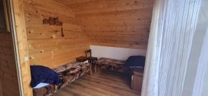a room with two beds in a wooden cabin at Domek Na Hawajach in Polana