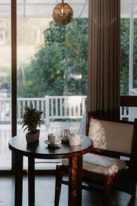 a table with tea cups and a potted plant on it at Django Villa Weligama in Weligama